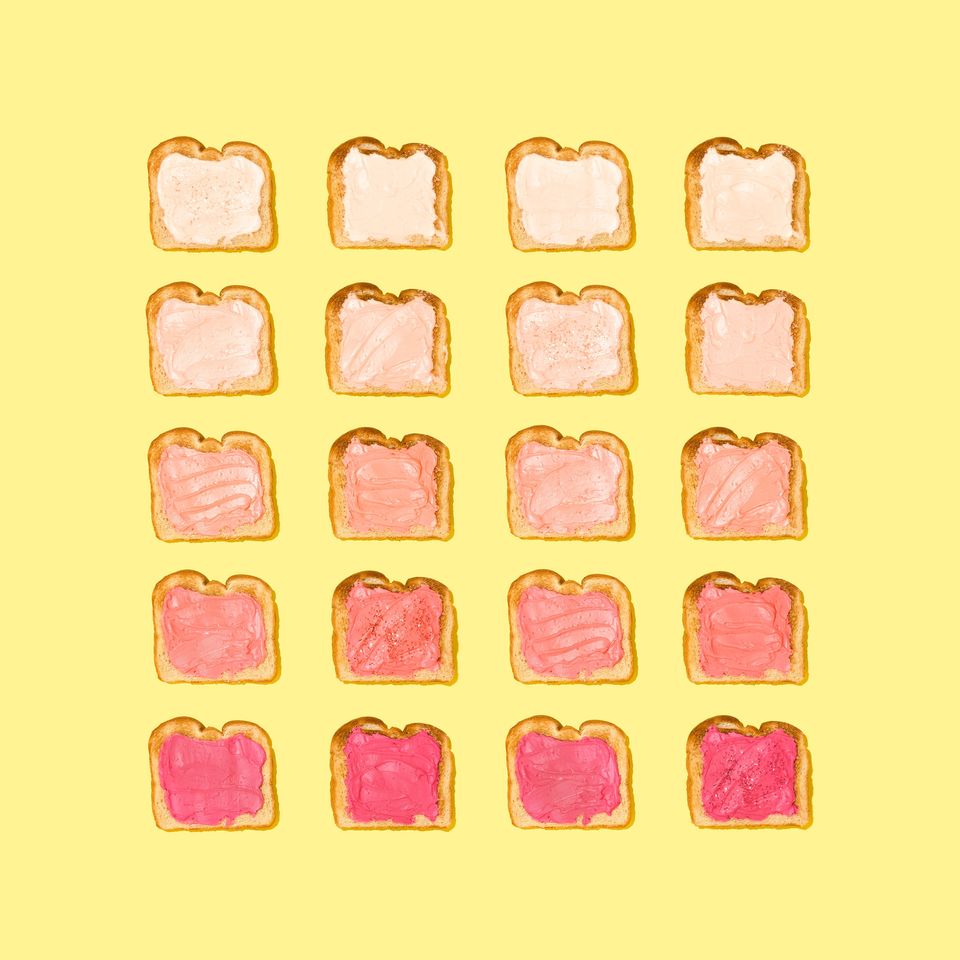 Yellow background with rows of toast 5x5 with pink spread on them lightest to dark pink, top to bottom row.